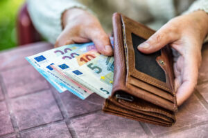 Pensioner woman holding in hands wallet with money